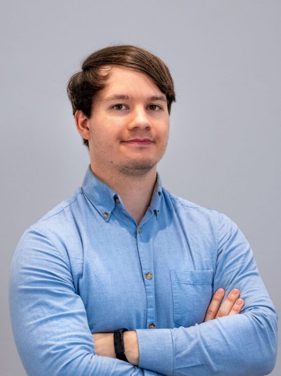 Man wearing blue shirt with arms crossed